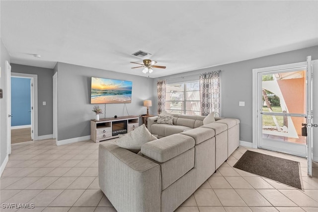 living room with visible vents, baseboards, light tile patterned flooring, and a ceiling fan