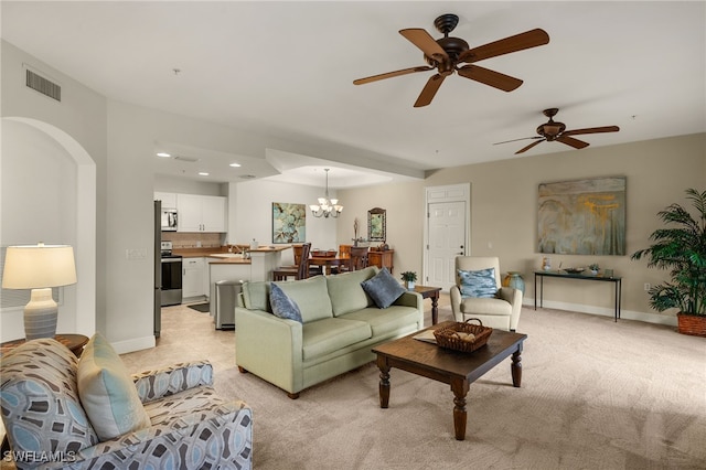 living area featuring arched walkways, baseboards, visible vents, and a notable chandelier