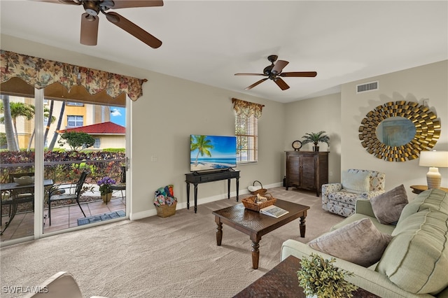 carpeted living room featuring ceiling fan, plenty of natural light, visible vents, and baseboards