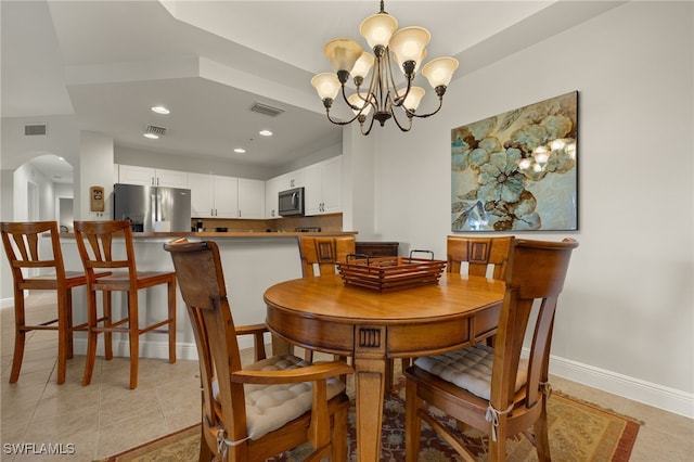 dining room featuring visible vents, arched walkways, a notable chandelier, and light tile patterned flooring