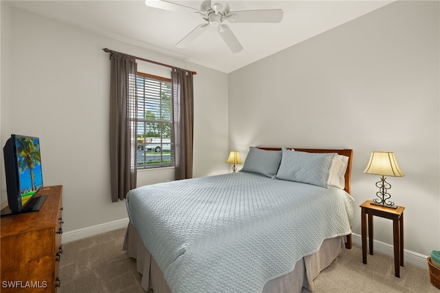 carpeted bedroom with ceiling fan and baseboards