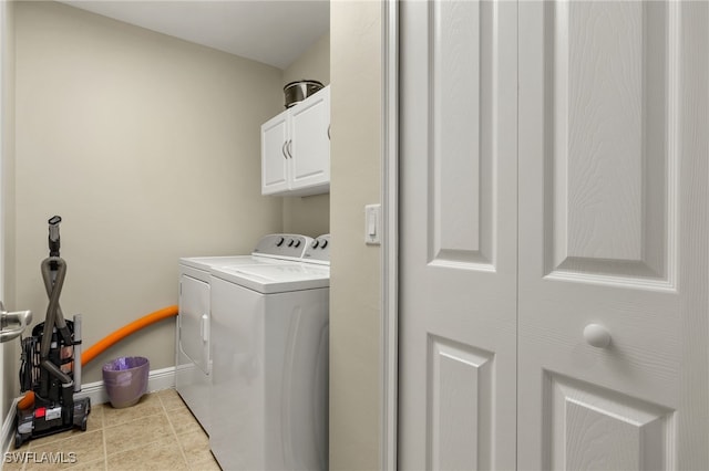 clothes washing area featuring cabinet space, tile patterned floors, baseboards, and washing machine and clothes dryer