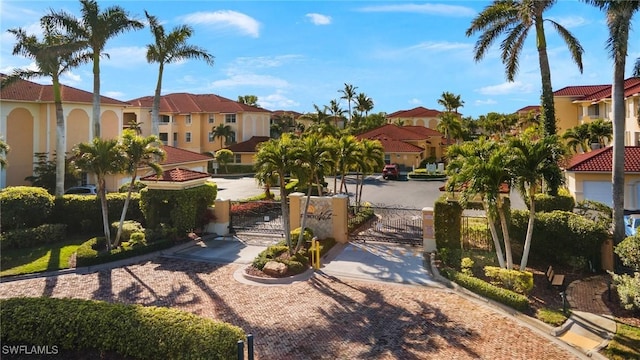 exterior space featuring a residential view, a gate, curbs, and a gated entry