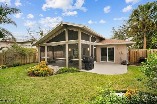 back of property featuring a sunroom, a patio area, fence, and a yard