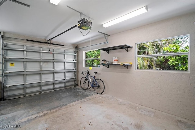 garage featuring a garage door opener and a textured wall