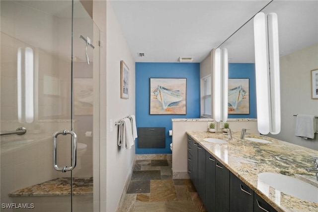 bathroom featuring a shower stall, visible vents, and a sink