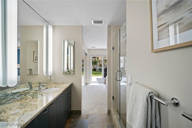 full bathroom with vanity, a shower stall, and visible vents