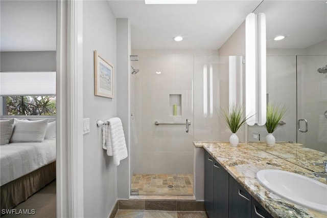 bathroom featuring a skylight, a shower stall, vanity, and recessed lighting