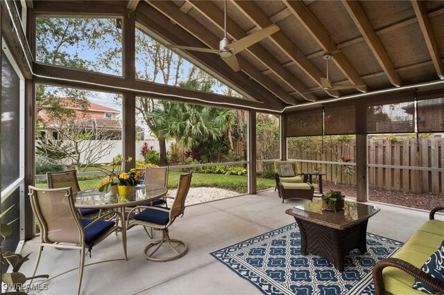 sunroom with a healthy amount of sunlight, vaulted ceiling, and ceiling fan