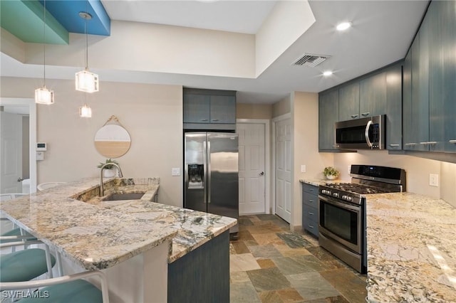 kitchen with visible vents, appliances with stainless steel finishes, stone finish floor, a sink, and a kitchen bar