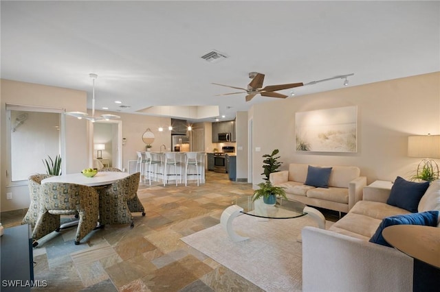 living room with track lighting, recessed lighting, visible vents, and a ceiling fan