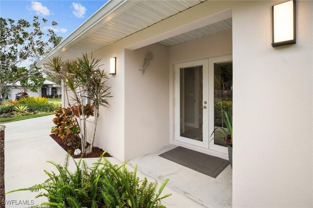 doorway to property featuring french doors and stucco siding