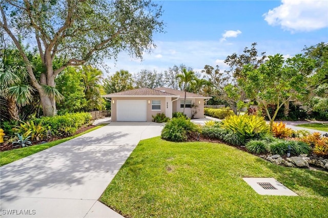 view of front of property with driveway, stucco siding, a garage, and a front yard