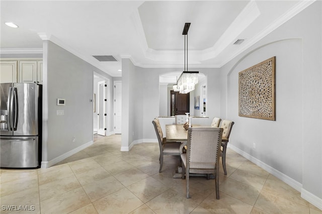 dining room with ornamental molding, a tray ceiling, visible vents, and baseboards