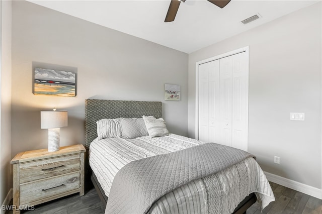 bedroom featuring dark wood-style floors, a closet, visible vents, a ceiling fan, and baseboards