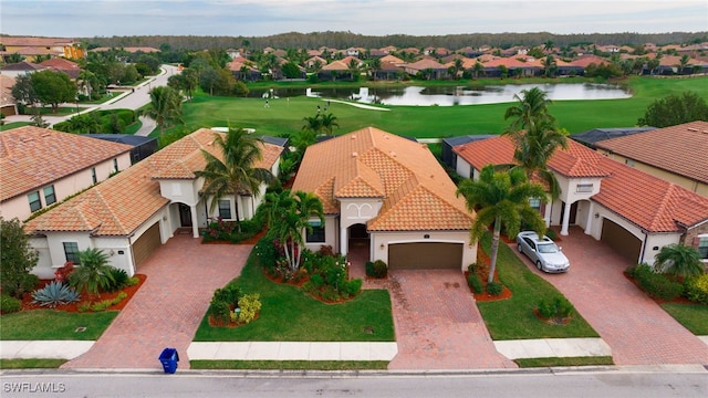 drone / aerial view featuring a residential view, view of golf course, and a water view