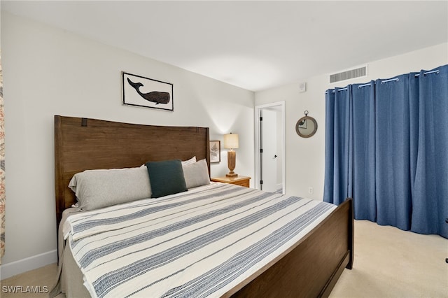 bedroom with visible vents and light carpet