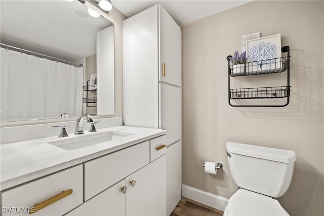 full bath featuring vanity, toilet, and baseboards