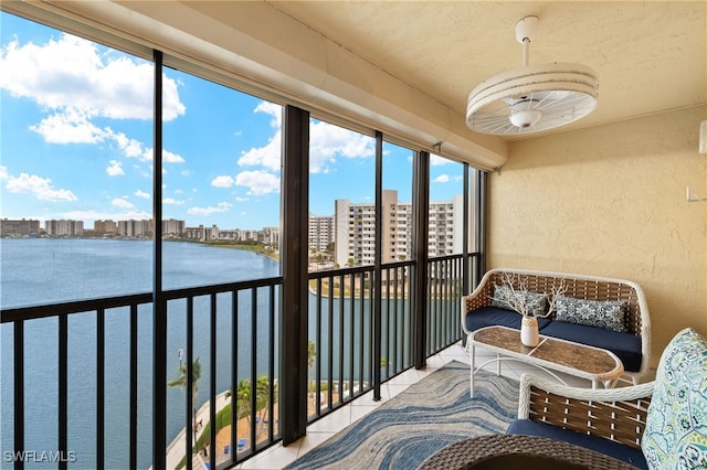 sunroom featuring a view of city and a water view