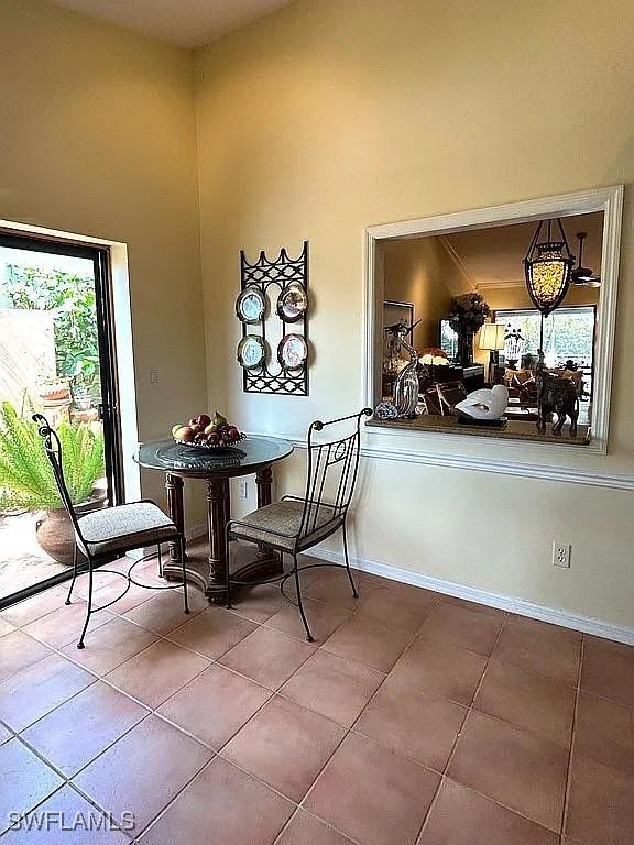 dining space featuring baseboards, a high ceiling, and tile patterned floors