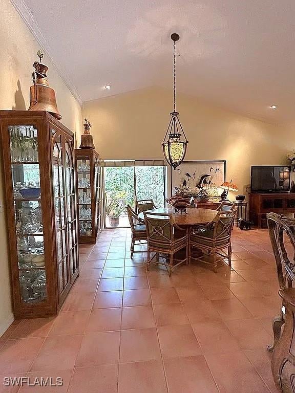 dining area with lofted ceiling, a textured ceiling, and light tile patterned flooring