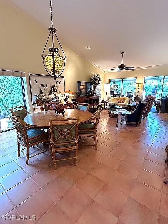 dining area featuring light tile patterned floors, high vaulted ceiling, and a ceiling fan