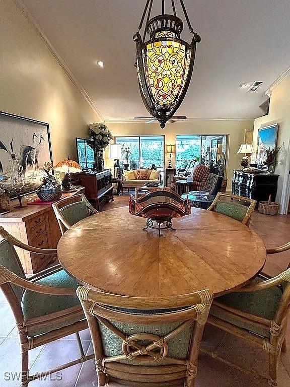 dining room featuring visible vents, ornamental molding, and tile patterned flooring