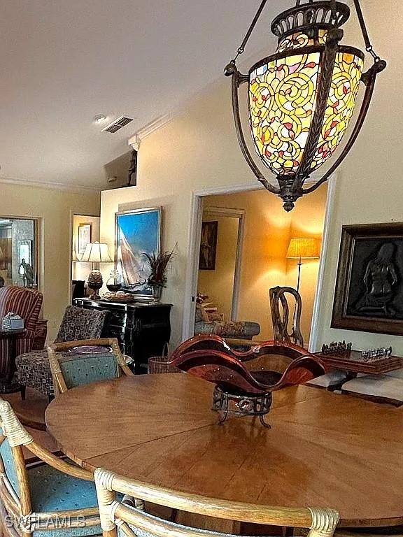 dining space featuring lofted ceiling and visible vents