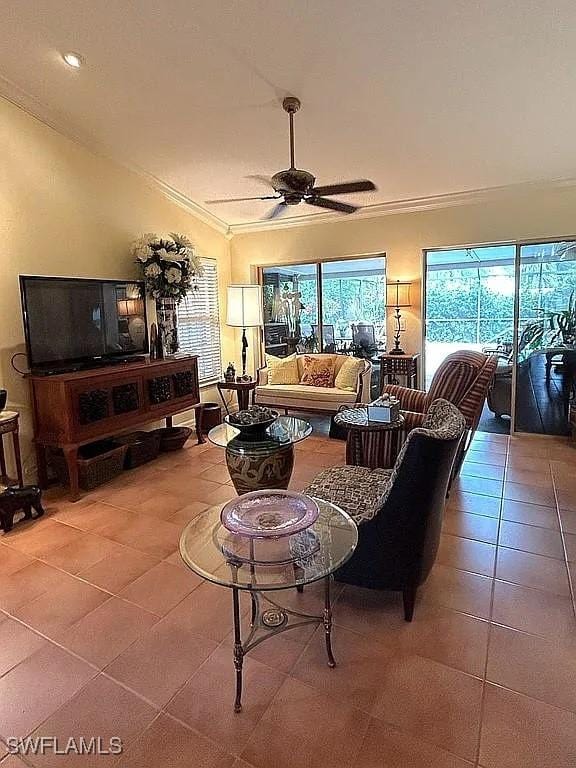 tiled living room with ceiling fan and crown molding