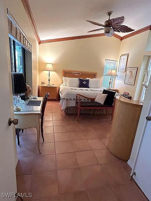 bedroom with ornamental molding and tile patterned floors