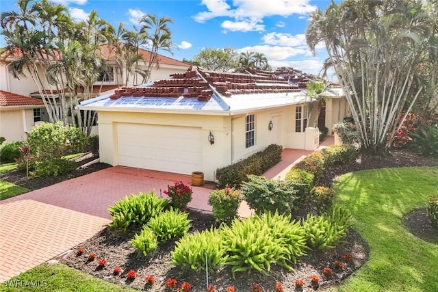 mediterranean / spanish-style home with an attached garage, decorative driveway, and stucco siding