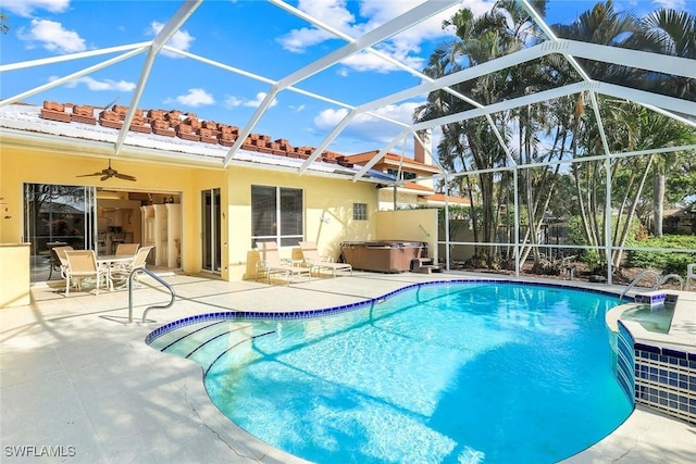 pool with a patio area, a hot tub, and glass enclosure