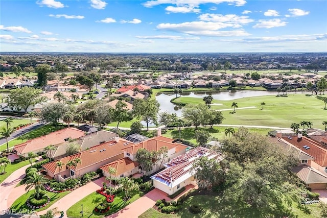 drone / aerial view featuring view of golf course, a water view, and a residential view