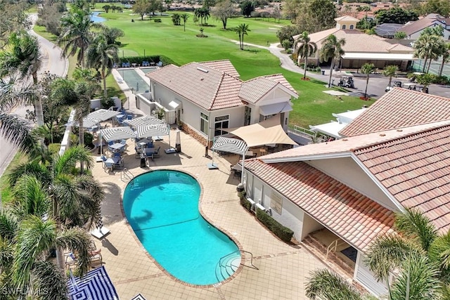 community pool featuring golf course view, a patio area, and fence