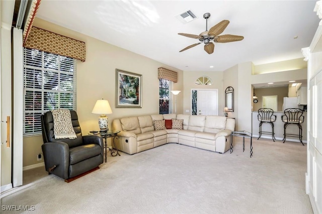 living room featuring carpet floors, visible vents, ceiling fan, and baseboards