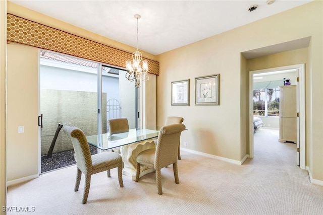 dining room with baseboards, a chandelier, and light colored carpet