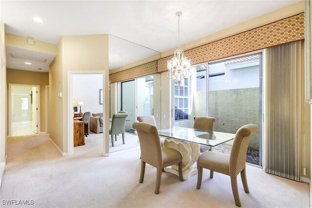 dining space with baseboards, a notable chandelier, and light colored carpet