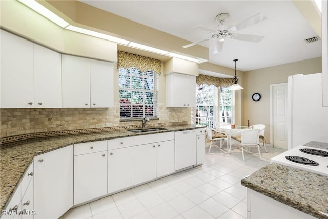 kitchen with white appliances, backsplash, a sink, and white cabinets