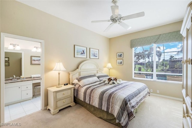 bedroom with light carpet, ceiling fan, baseboards, and connected bathroom