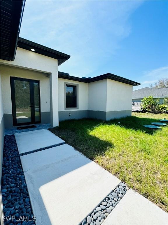 exterior space with a lawn and stucco siding