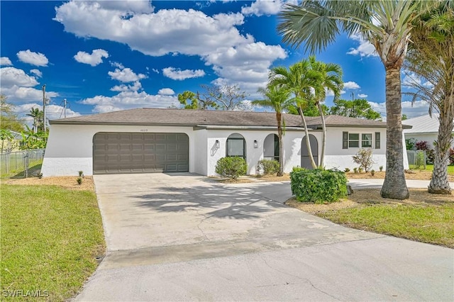 ranch-style home featuring driveway, an attached garage, fence, and stucco siding