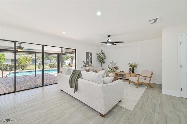 living area featuring ceiling fan, visible vents, baseboards, and recessed lighting