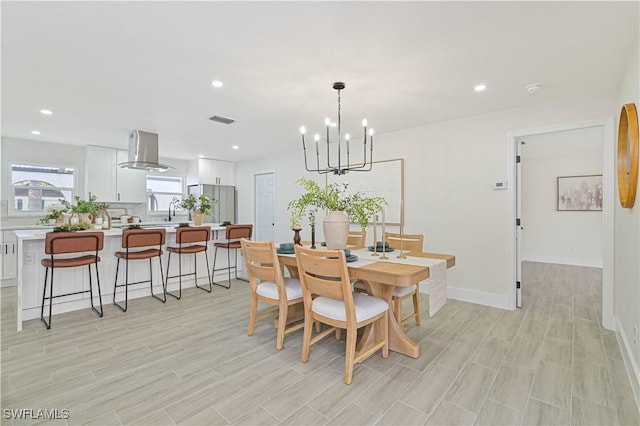 dining space featuring baseboards, visible vents, light wood-style flooring, an inviting chandelier, and recessed lighting