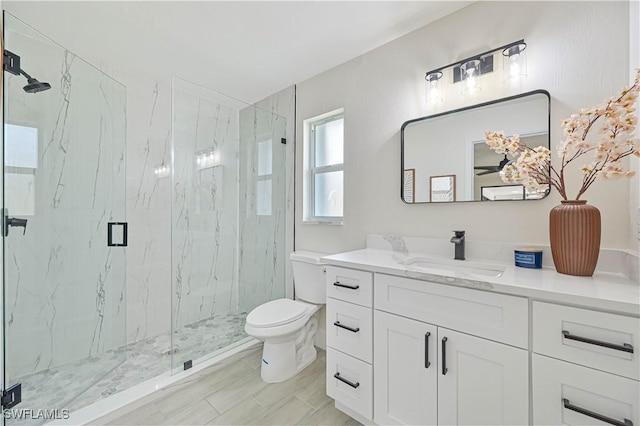 bathroom with toilet, a marble finish shower, and vanity