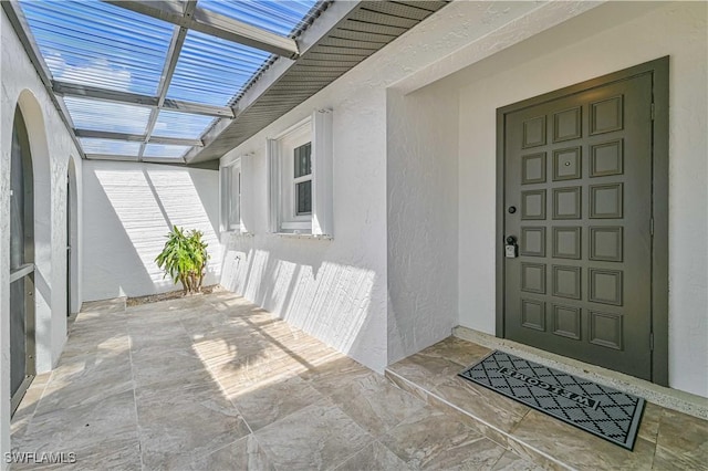 doorway to property with a patio and stucco siding