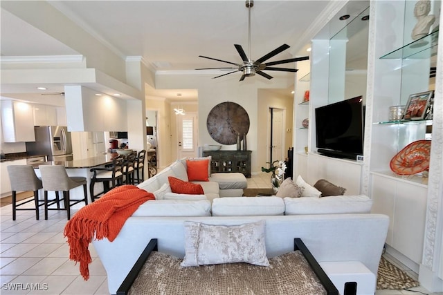 living area featuring light tile patterned floors, built in shelves, ornamental molding, and a ceiling fan