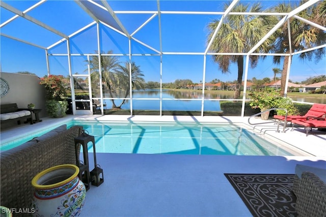 pool with glass enclosure, a patio, and a water view