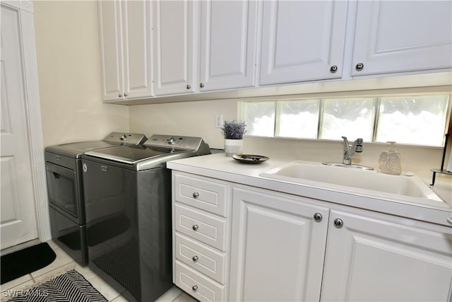 laundry room with washer and clothes dryer, light tile patterned flooring, a sink, and cabinet space