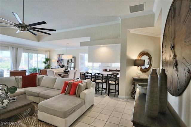 living area featuring light tile patterned floors, visible vents, a raised ceiling, ceiling fan, and crown molding