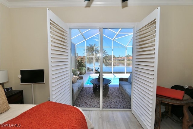 bedroom featuring a water view, wood finished floors, a sunroom, access to exterior, and crown molding